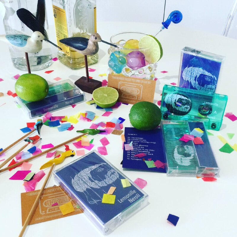 Lemonille new album 'Neroli' in cassette format on table with lime confettis and drinks Lemonille new album 'Neroli' in cassette format on table with lime confettis and drinks